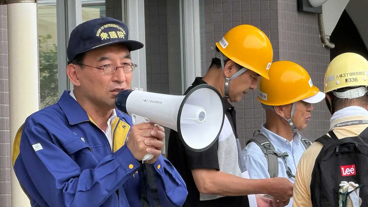 衆議院議員・西園勝秀が地域の防災活動で住民に呼びかける様子